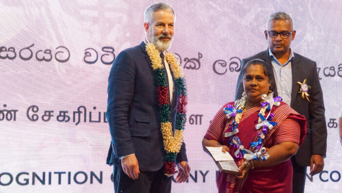 a woman holding a certificate, standing next to a man. 