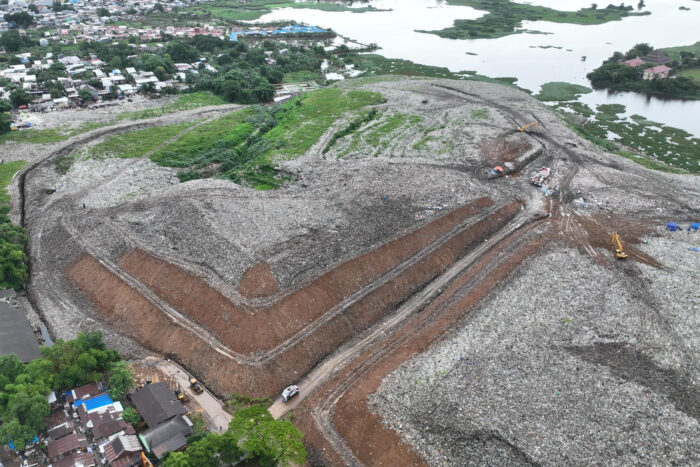 Aerial view of a dump that has been properly managed, with garbage in the process of being covered in dirt so that it doesn't blow away.