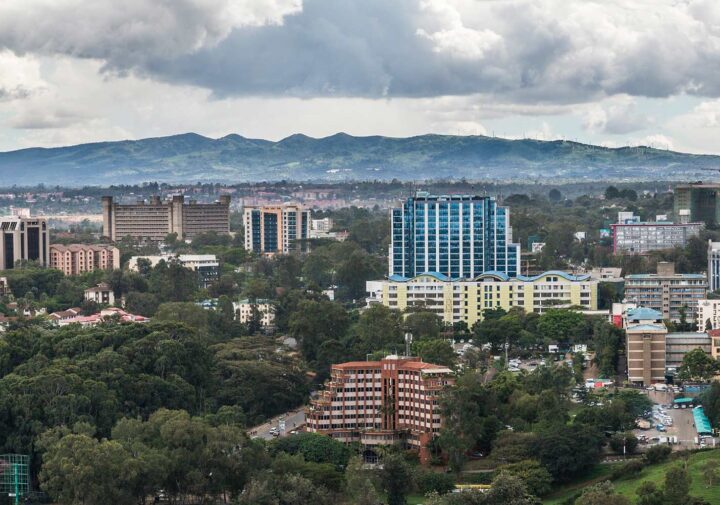 Image: View of Nairobi, Kenya from atop a tall building. Mountains can be seen in the distance.