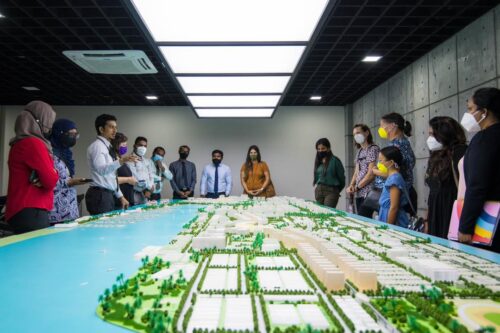 people standing around table with map model