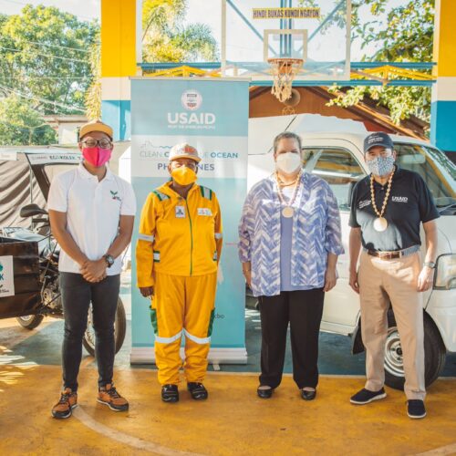 4 people standing in front of waste collection vehicles