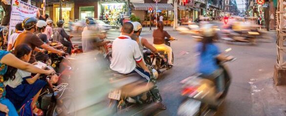 Image: Motorbikes zoom by in a blur on a busy street in Vietnam.