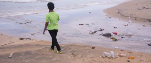 Young man walks along Ratmalana Aurban side Beach.