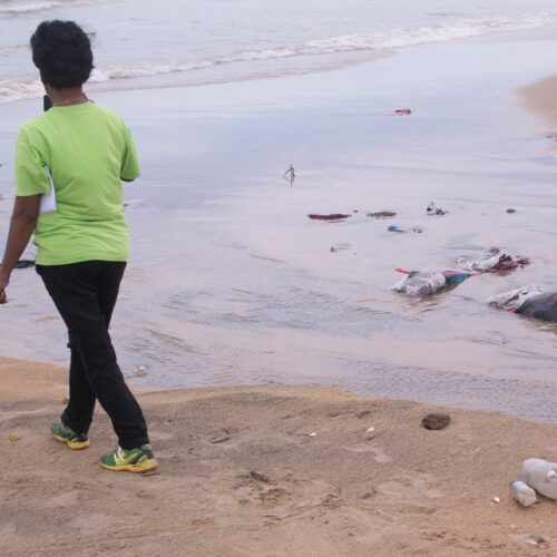 Young man walks along Ratmalana Aurban side Beach.